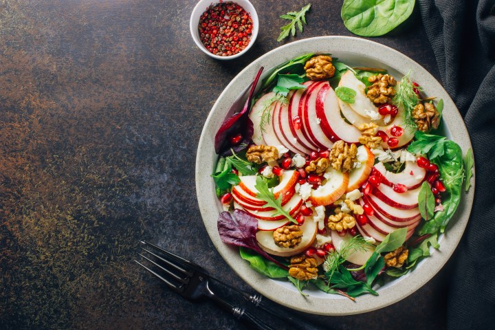 Healthy multi greens salad plate with apple, walnut, pomegranate, cheese